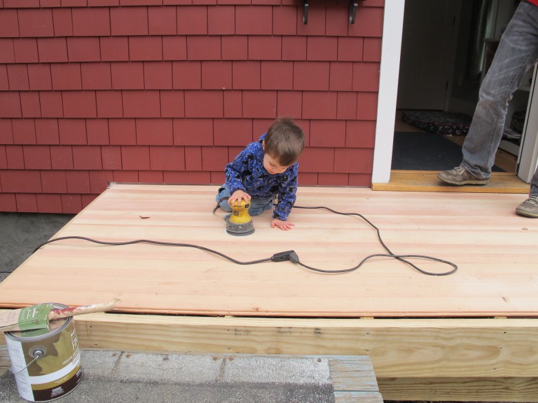 kurt bergstom's son helps sand a new deck